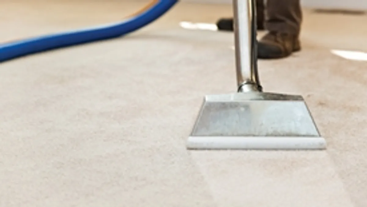 Carpet cleaning wand head gliding over a light carpet during hot-water extraction, Columbus, GA.