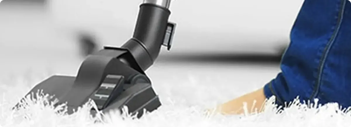 Close-up of a professional vacuuming a white carpet in Midland.